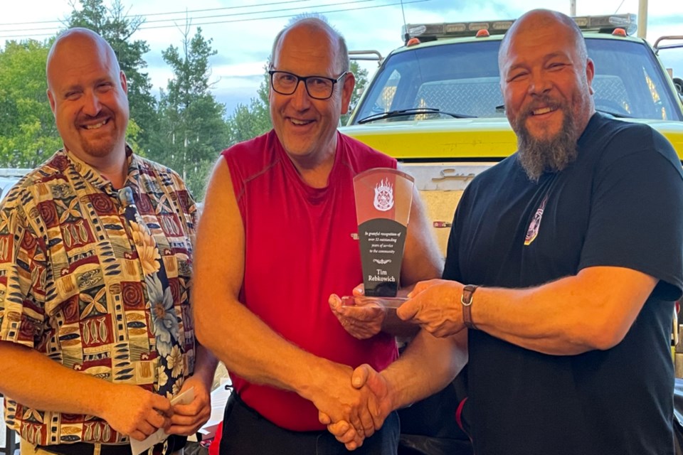 Tim Rebkowich (middle) has been a firefighter with the Wandering River Fire Department for so long no one was sure exactly how many years he put in before recently retiring. It could be 30 or it could be 40, but they settled on 32 and he was presented with an award by Athabasca County Coun. Gary Cromwell (left) and chief Andy Snegirev (right) July 15 at a supper held at the fire hall.