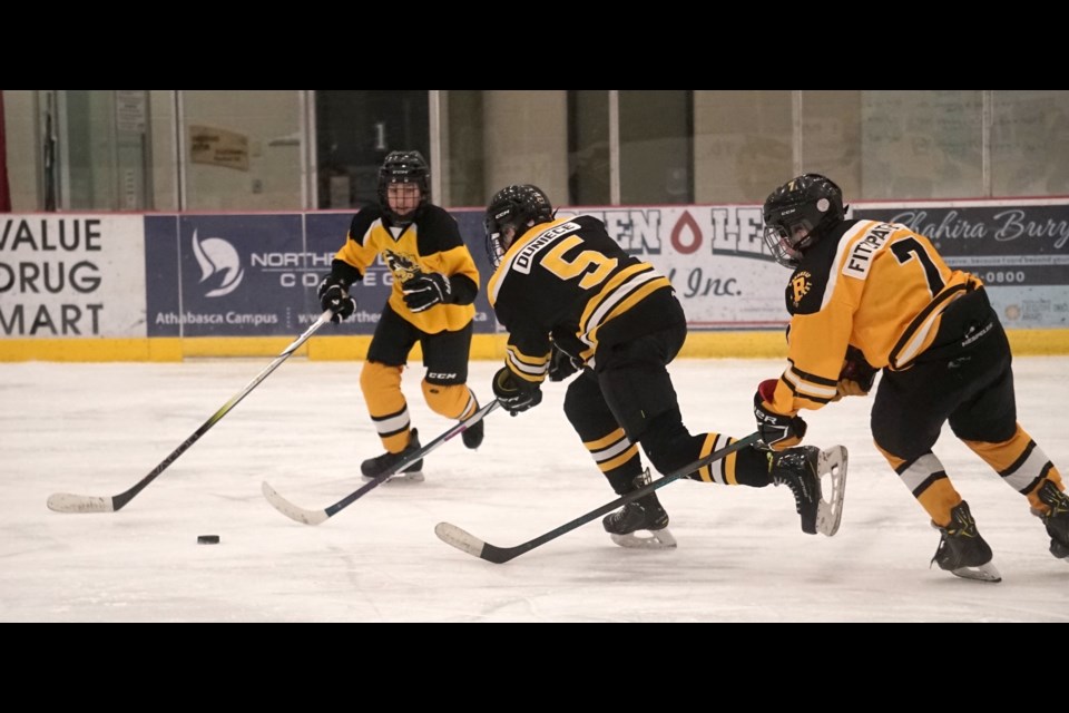 Barrhead’s Lucas Kent, left, and #7 Ben Fitzpatrick close in on Athabasca’s Owen Duniece as U15-1 teams went head to head for a close game.                                