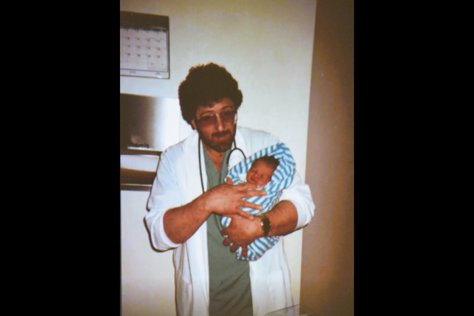 A picture of Dr. Marvin Wray holding a babt that was shown during a fundraiser to name the all-wheel park in his honour on Feb. 11 at the Seniors' Drop-in Centre.