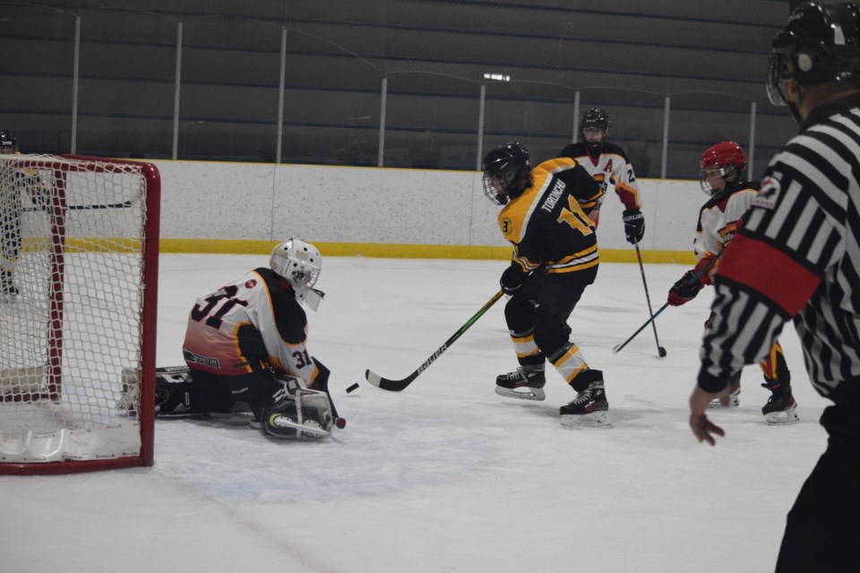 Barrhead Buck player Nathaniel Toronchuck is stopped by Westlock netminder Derek Dul.