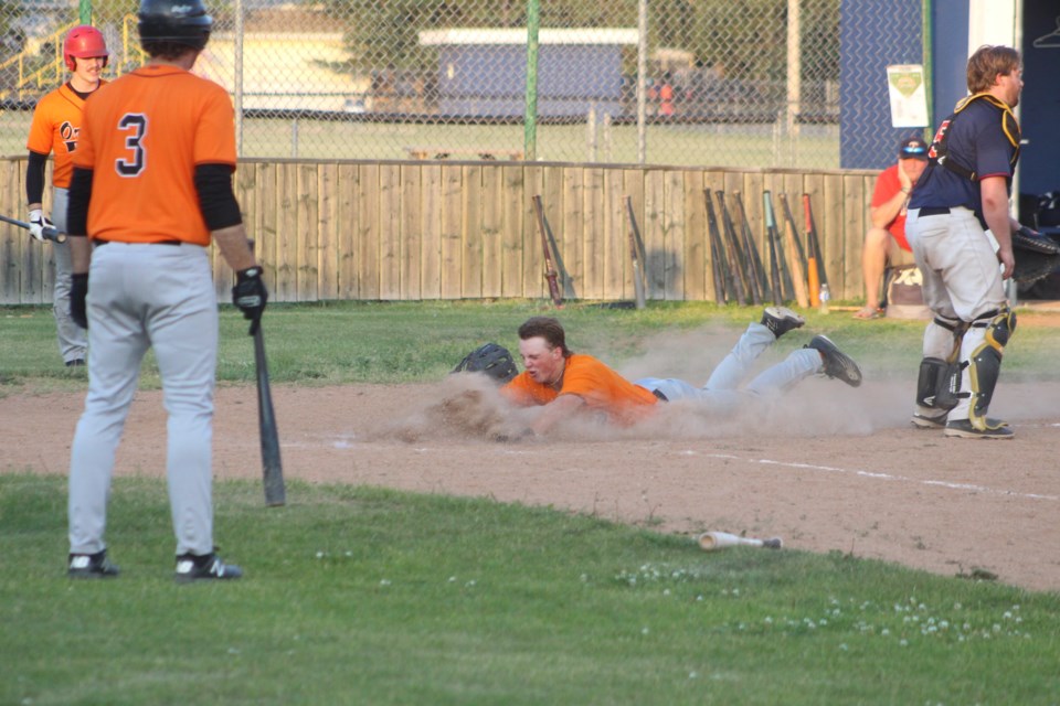 Barrhead Oriole Jamie Visser slides head first into home for his second on-field homer.