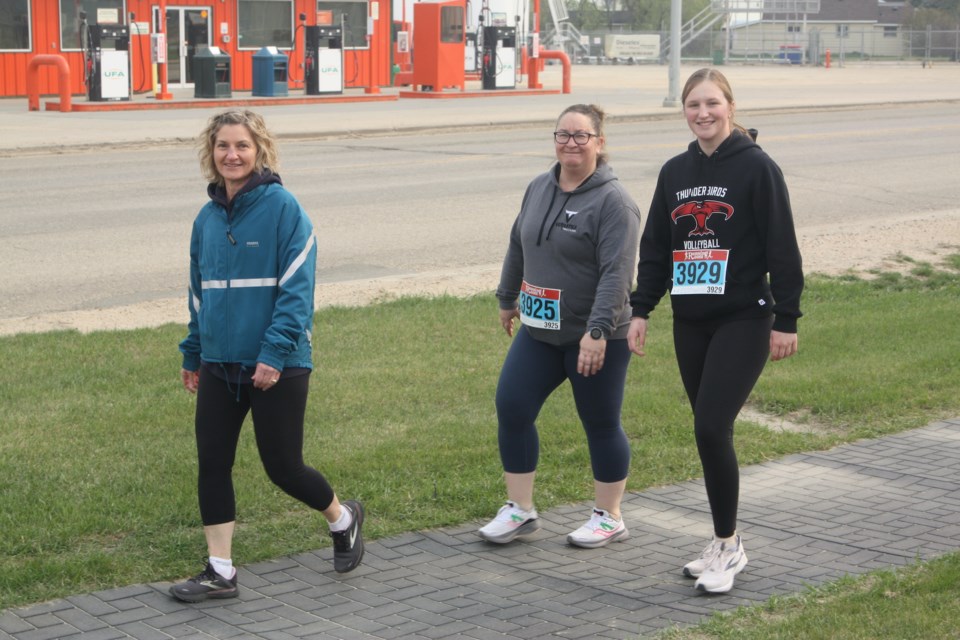 Jackie Huppertz, Aimee Fortier and Heidi Huppertz stroll along the Rotary Trail next to Highway 18.