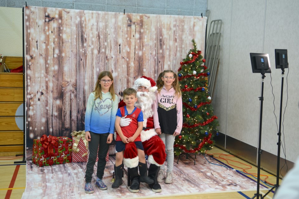 The Smith siblings Mackenzi, Levi and Chelsea pose with Santa.