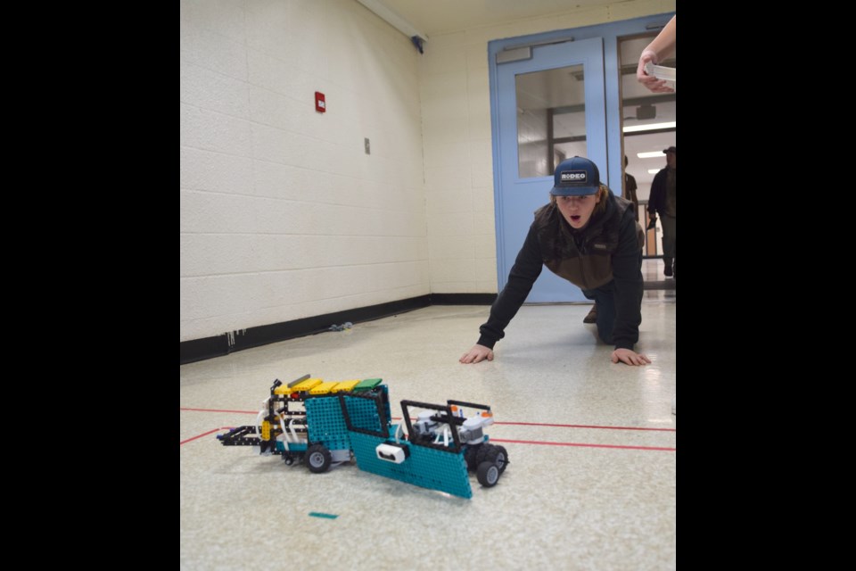 Tribben Harding getting an eye-level view of his robot in competition.