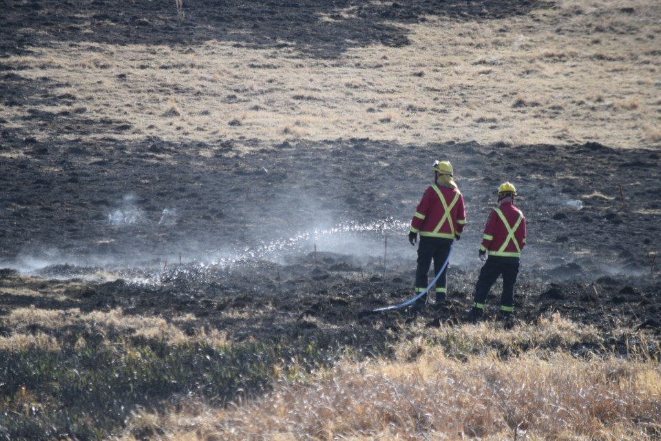 Two Barrhead Regional Fire Services firefighters work on a hot spot of a wildfire on Township Road 563A near Range Road 13 near the border of Lac Ste. Anne on April 14.