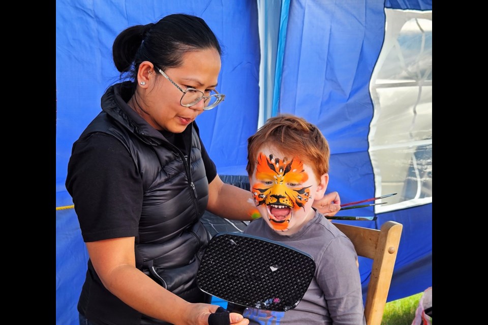 Westlock’s James Rhoad reacts with a smile to his tiger face, painted by artist Gracie Malone. 