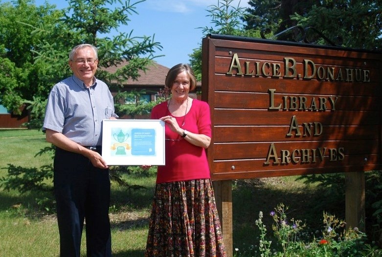 Alice B. Donahue Library and Archives board member and treasurer Bob Tannas and library manager Cynthia Graefe display the certificate for the Blue Sky Award. The library is