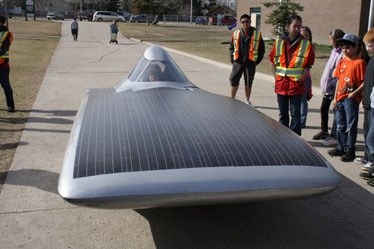 University of Calgary Solar Team driver Steph Hladik sits in the team&#8217;s car, Schulich Axiom, in front of Barrhead Elementary School on May 2. The team was on a tour of