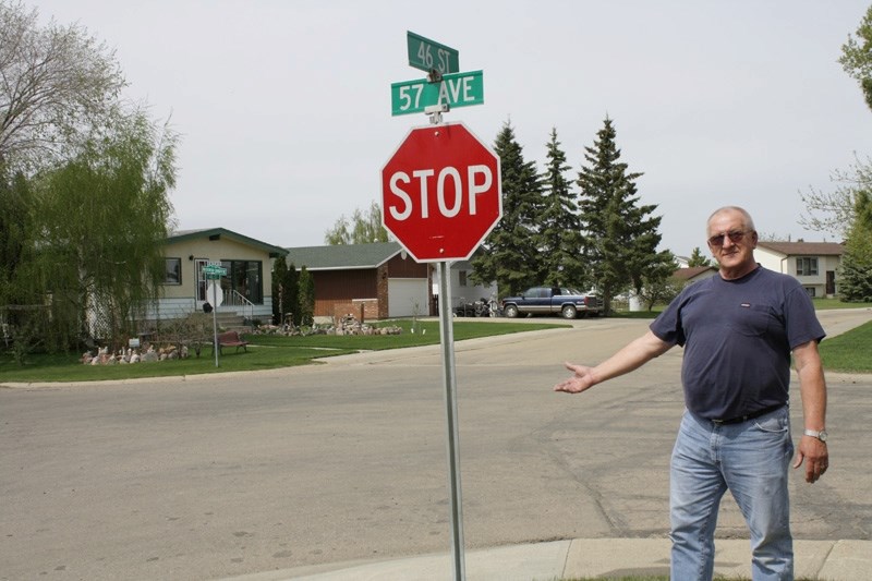 George Peters gestures to the intersection of 46 Street and 57 Avenue. He and several neighbours want the town to put a four-way stop at the corner to slow down traffic.