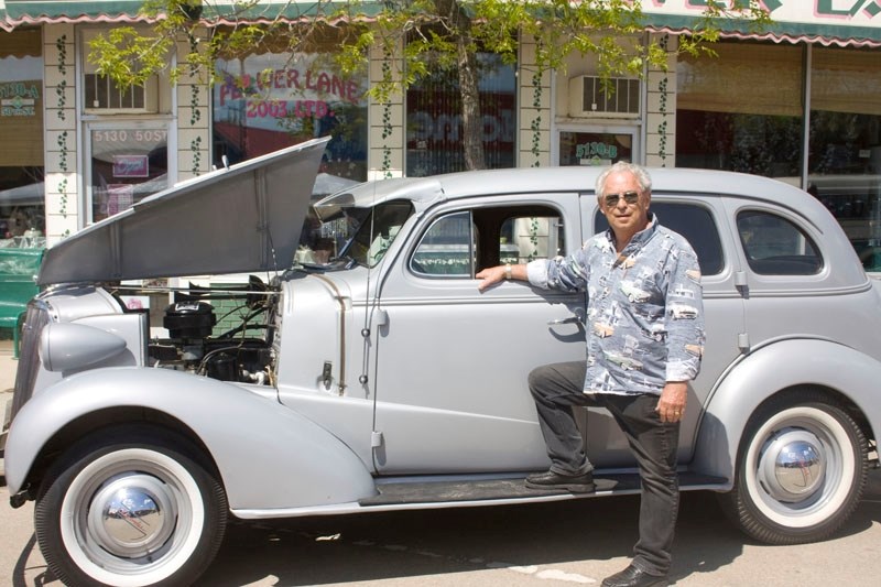 Vernon McFadzen stands proudly next to his grey 1937 Chevrolet.