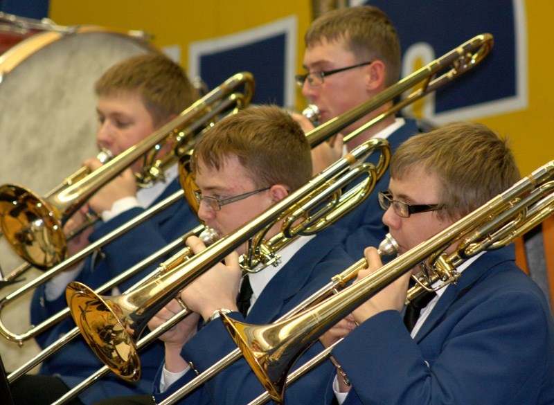 Front to back: Andrew Millar, Luke Vanderwekken, Mark Fountain and David Kleinfeldt play trombones for the Grade Eight/Nine/Senior Band during the Christmas concert.