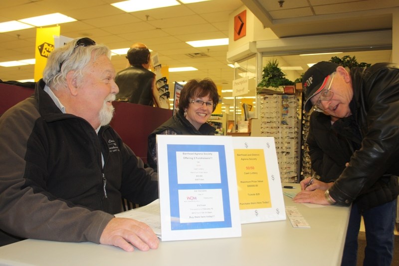 County councillor Bill Lane and Carla Carlson selling 50/50 tickets at the Co-op last Thursday. Buying a ticket is George Andrews, Co-op president.