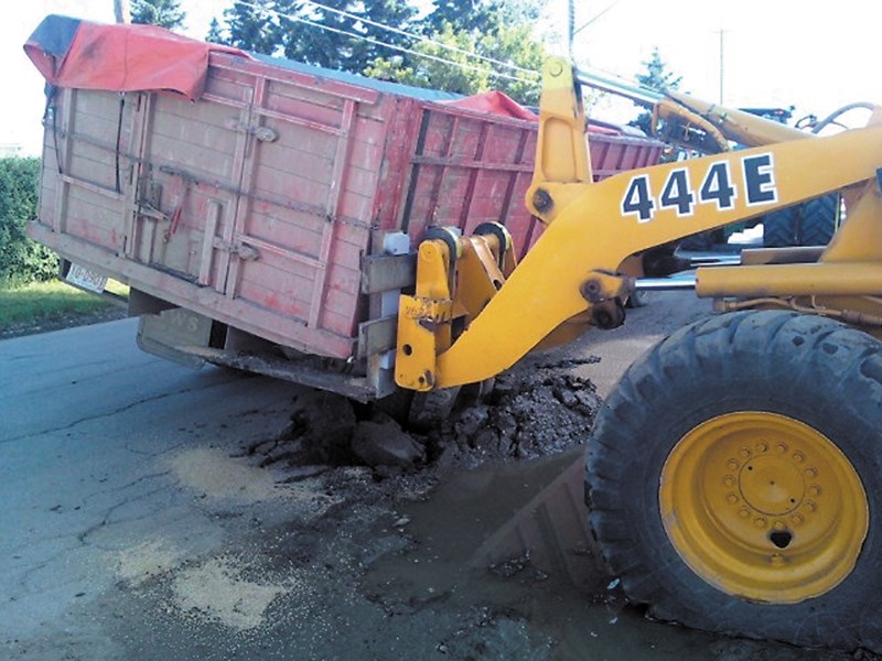 Heavy equipment was required to lift a grain truck out of a hole in the asphalt after it broke through near Westlock Terminals.