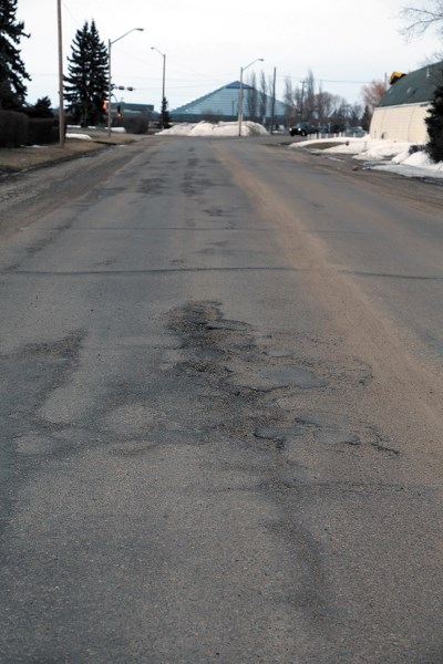 Potholes on town roads, like this one on 106 Street at 103 Avenue, will be patched this spring and summer. The town is also looking at doing major road work if the price is