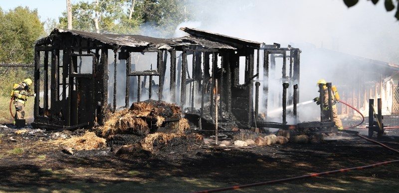 Westlock Rural and Clyde firefighters douse a burning home southeast of Clyde last Thursday afternoon. The fire destroyed the home, but the lone occupant at the time escaped