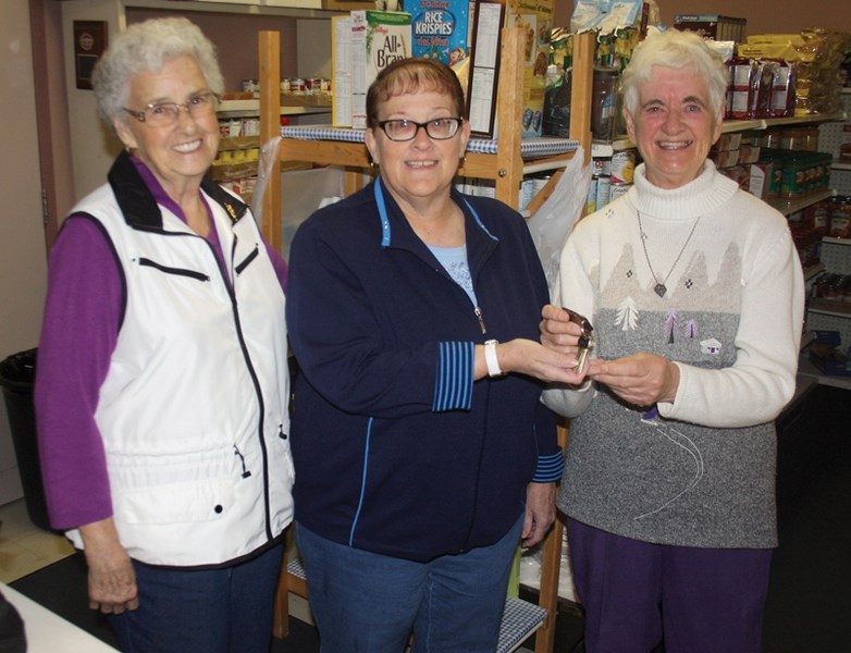 Outgoing Westlock Food Bank president Sister Eileen (right) hands the keys over to new president Sharon Kennedy (centre) and secretary Edna Kieser. Sister Eileen is stepping