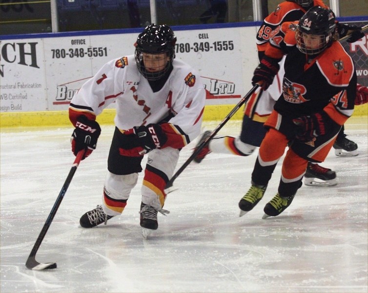 Pee wee Warrior Zachary Basisty plays keep away with a CR Knights player on Saturday, Oct. 31 at the Rotary Spirit Centre. The Warriors posted a 2-2 tie to improve to 2-0-1