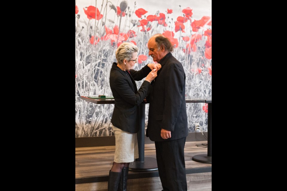 Port Moody MP Bonita Zarrillo pins a King Charles III coronation medal on the lapel of David Bennie of the Port Moody Ecological Society, on Nov. 9, 2024.