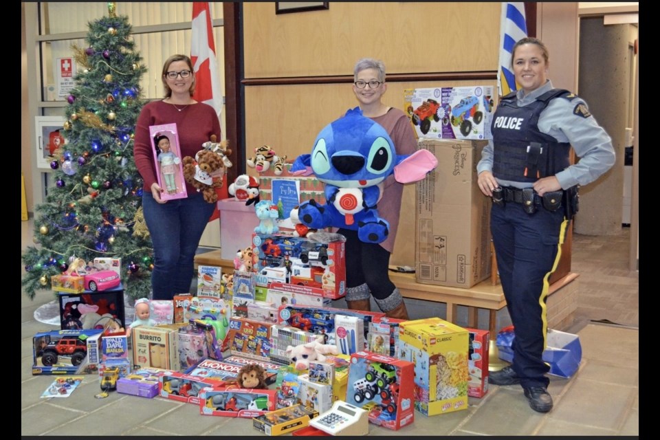 Left to right, Jennifer Criss, Sommer Kinney and Cpl. Alexa Hodgins with the 2022 haul for the 911 We Care Toy Drive, at Coquitlam RCMP.