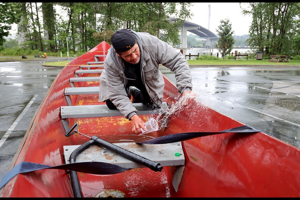 Francis Williams bails rainwater from the Haida canoe prior to its departure from Maquabeak Park in Coquitlam for the final leg of the Grandmothers canoe journey to deliver a chest of artwork, stories and poems to New Westminster where it will they will be put on display at that city's museum and archives.