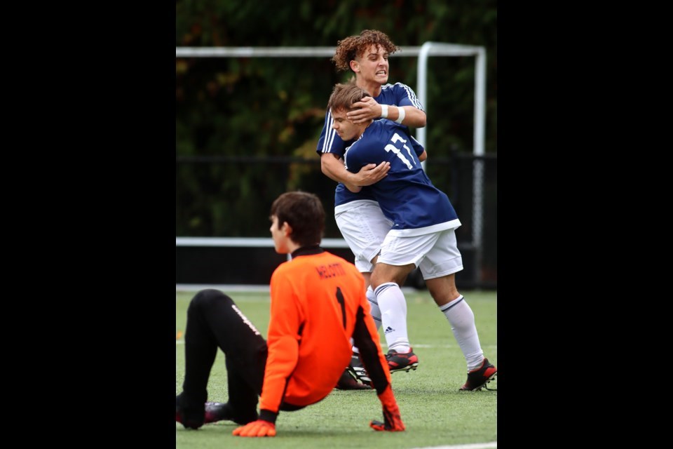 Dr. Charles Best Blue Devils forwards Luca Di Francesco and Stefan Tent celebrate Tent's opening goal over a fallen Burnaby North goalkeeper Eduardo Melotti in the first half of their 2021 Fraser North Zone playoff match at Dr. Charles Best Secondary. The Blue Devils won 3-0.