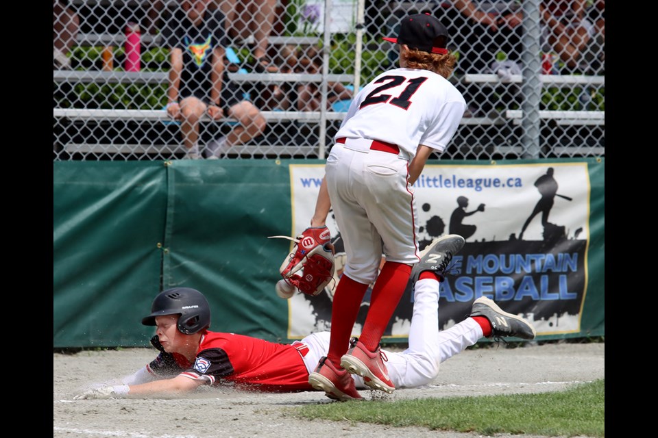 A Firebirds base runner beats the throw to home plate after a passed ball in their game against at the 2024 Little League Intermediate Canadian Championship that started Wednesday at Mackin Park in Coquitlam.