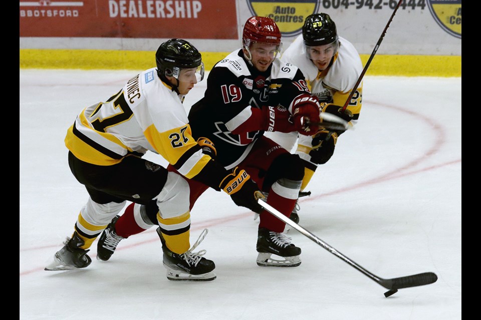 Coquitlam Express forwards Joseph  Odyniec and Andrej Kovacevic squeeze Chilliwack Chiefs winger Mateo Mrsic off the puck in the first period of their BC Hockey League season opener, Friday at the Poirier Sport and Leisure Complex.