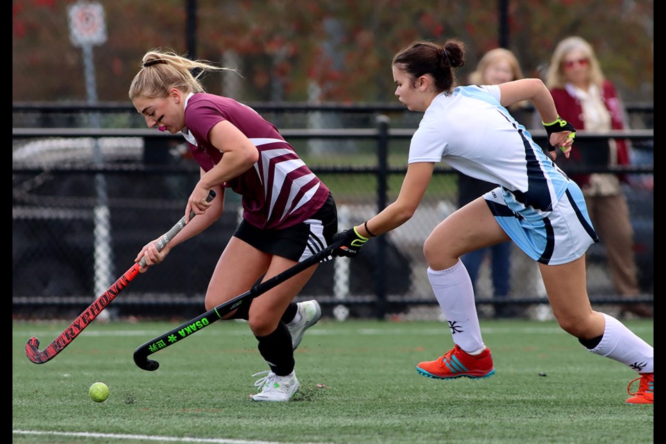 Heritage Woods Kodiaks forward Abby Mallow streaks around a Dr. Charles Best Blue Devils defender in the third quarter of their SD43 senior girls field hockey final, Thursday at Coquitlam's Town Centre Park. The Kodiaks won the match, 2-0.