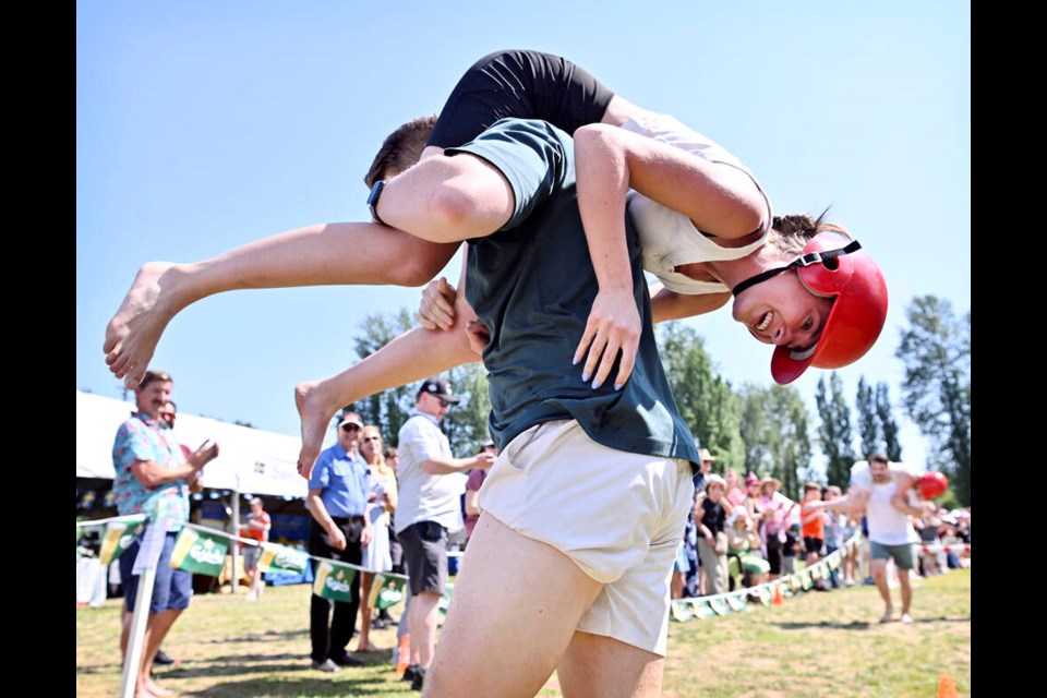 Eric Blaida and Anna Stonkevich of Coquitlam cross the finish line to win the Wife Carrying Contest, and Anna's weight in beer, at the Scandinavian Festival in Burnaby on Sunday (JUne 25). | Jennifer Gauthier, Tri-City News 