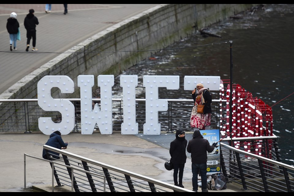 Fans are stopping to pose with the "Swiftcouver" sign which is set up in Coal Harbour and is part of a 13-sign installation around Vancouver to welcome Taylor Swift and the Eras Tour on its final stop in December 2024.