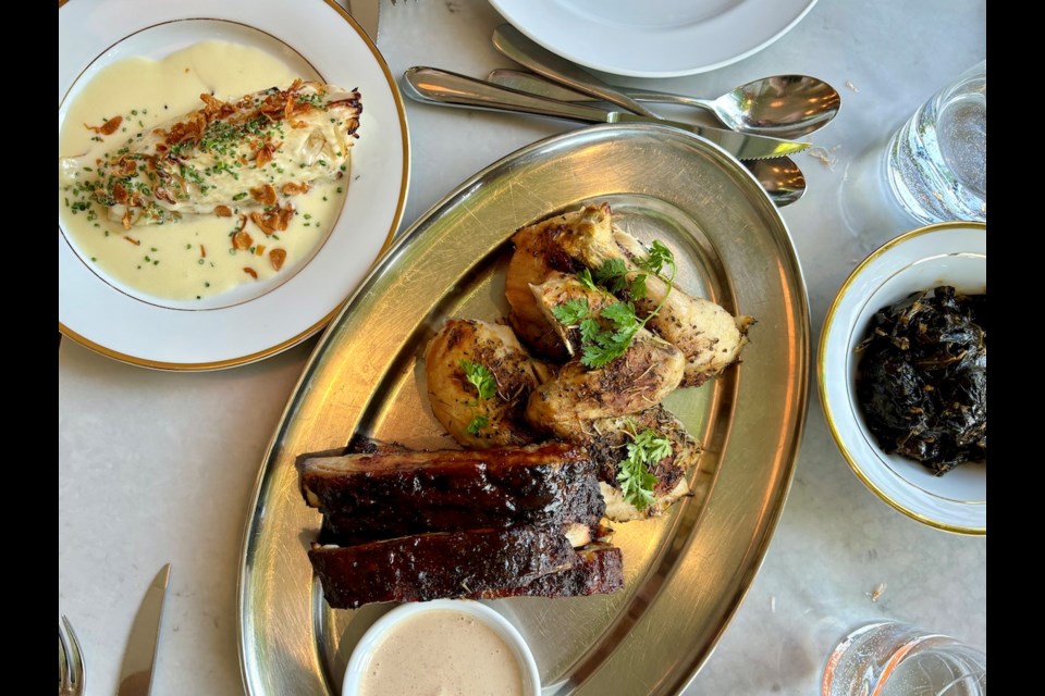 Ribs and roasted chicken with Alabama BBQ sauce are joined by sides of spicy collard greens and cabbage in a creamy cheese sauce at Say Mercy!, a Vancouver restaurant featured in the Michelin Guide that serves a meld of Italian and Southern BBQ food