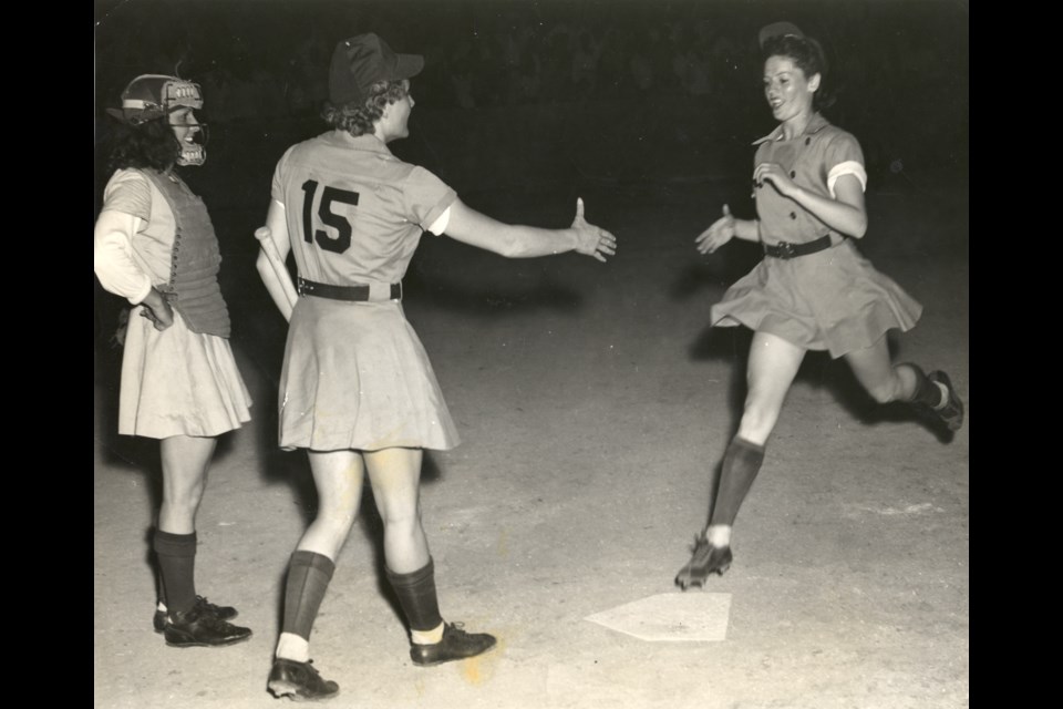 Margaret Callaghan, right, lands at home base following a homerun hit in a 1947 game.