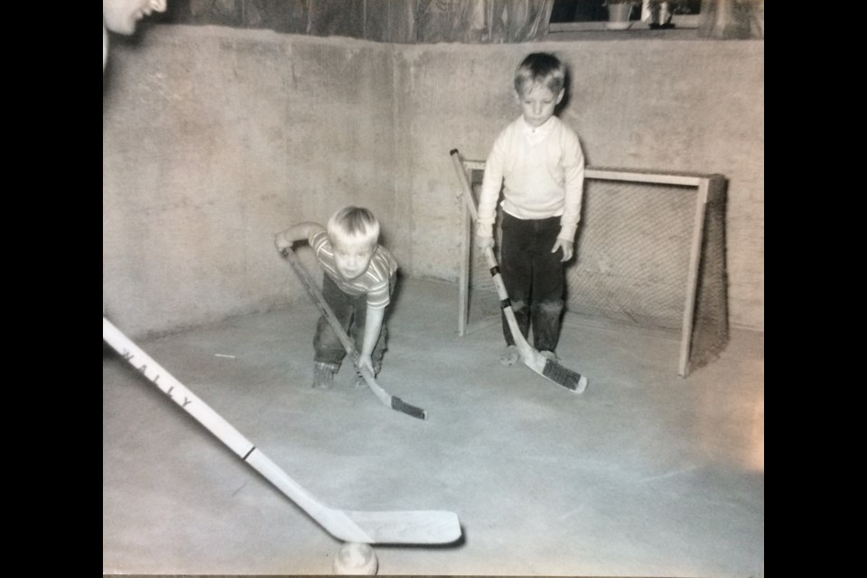 Cliff Ronning (middle) and older brother Todd (right) are at the homemade basement net as their dad (left) prepares to shoot them a tennis ball.