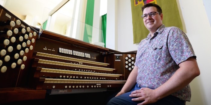  Holy Trinity Anglican Church’s musical director Michael Park along with the church’s 106-year-old Casavant organ.