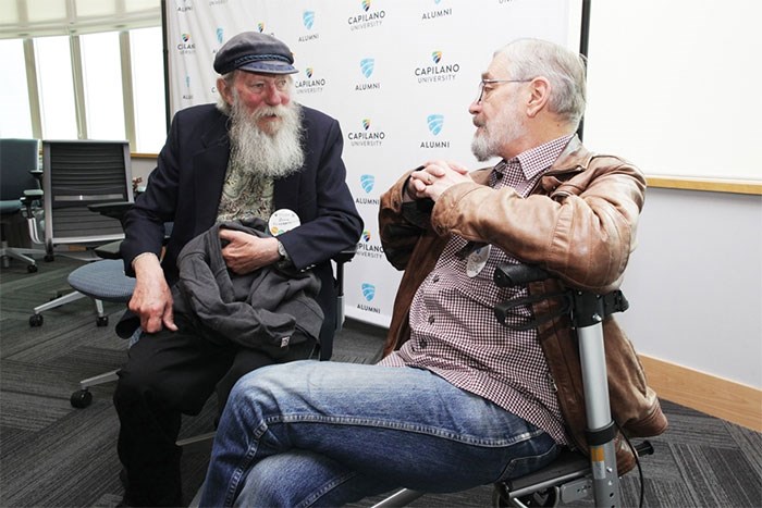  Original faculty member Bill Schermbrucker and former student Brad Ewing trade notes on old times at a party that celebrates the school’s journey from idea to college to university - photo Lisa King, North Shore News