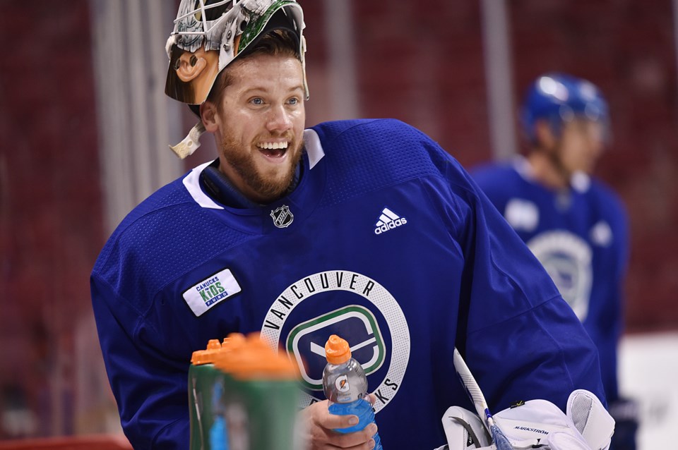 Jacob Markstrom enjoys a water break at the Canucks bench during practice.