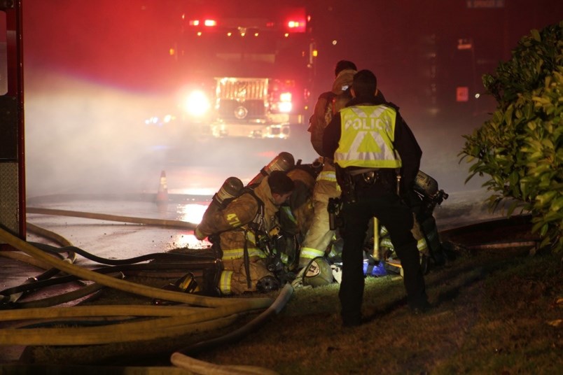 Firefighters perform CPR on a person pulled from a burning house in Burnaby early Tuesday morning. (via Ryan Stelting)