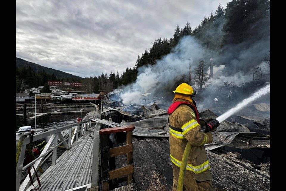 A firefighter mops up after a fire at Telegraph Cove on Tuesday, Dec. 31, 2024. ALERT BAY FIRE DEPARTMENT