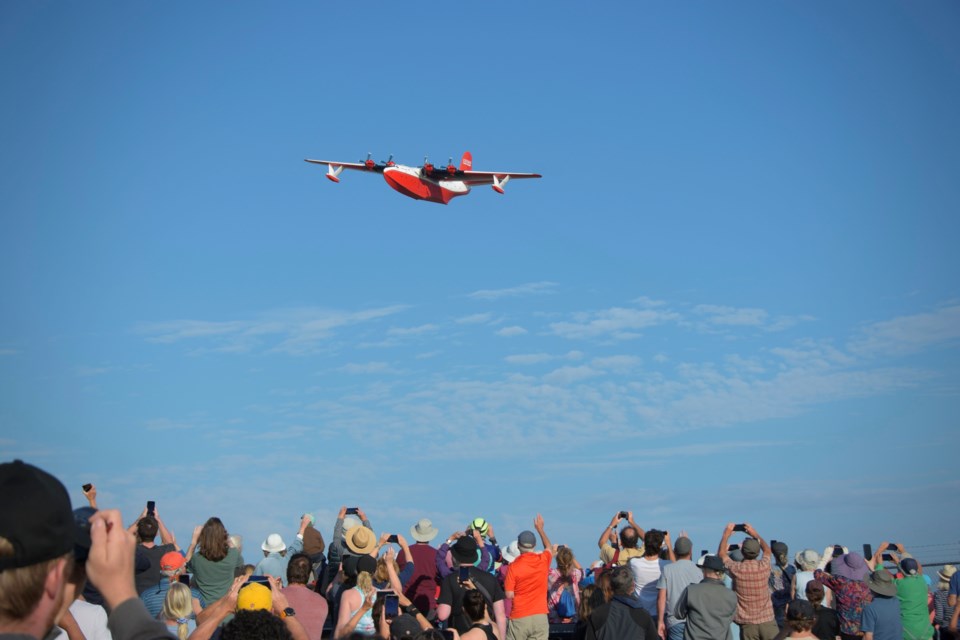 The Martin Mars soars over the crowd at Patricia Bay, as seen from close to the top of Hospital Hill, on Mills Road. Photo by Jen Wright 