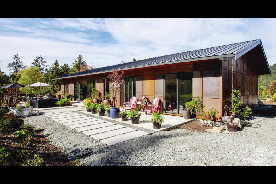 The owner had this North Saanich home built for her to age in place, with a low-maintenance exterior. The metal panels that serve as cladding are meant to rust in various shades of sepia, mahogany, burnt umber and ochre, creating a uniquely attractive effect. "I wouldn't have used this if I were building a house in Oak Bay," said the owner with a chuckle, but here it glows like burnished art in a forested area. The long, south-facing front patio has seating areas for lounging or dining. DARREN STONE, TIMES COLONIST