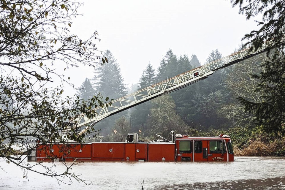 In this photo provided by the Lincoln County Sheriff's Department, a fire engine is surrounded by rising waters in Otis, Oregon, Friday, Nov. 12, 2021. The U.S. Coast Guard has used two helicopters to rescue about 50 people from rising waters at an RV park on the Oregon Coast Friday as heavy rains in the Pacific Northwest prompted warnings of floods and landslides. (Sgt. Jack Dunteman/Lincoln County Sheriff's Department via AP)