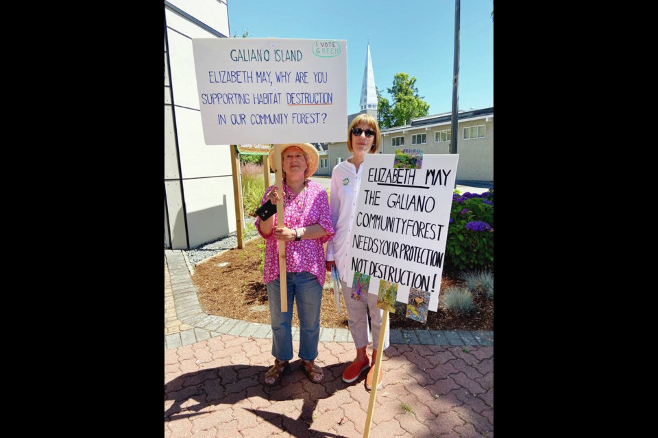 Carmita de Menyhart, left, and Jennifer Margison protest a non-profit organizations plan to build 12 lower-cost rental housing units on land that is part of a community forest on Galiano Island. The two went to Saanich-Gulf Islands MP Elizabeth Mays office in Sidney because she is a housing society board member. TIMES COLONIST 