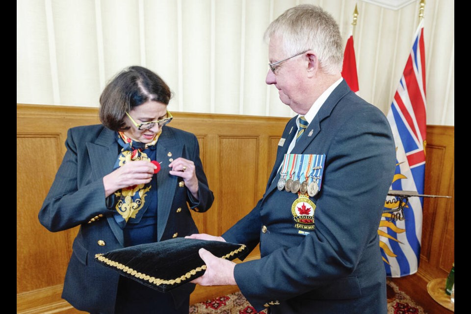 B.C. Lt.-Gov. Janet Austin is presented with the first poppy of the 2022 poppy campaign by Craig Thomson, president of the Royal Canadian Legion B.C./Yukon Command, at Government House on Tuesday. Funds raised support veterans, their families, seniors, and education programs. DARREN STONE, TIMES COLONIST 