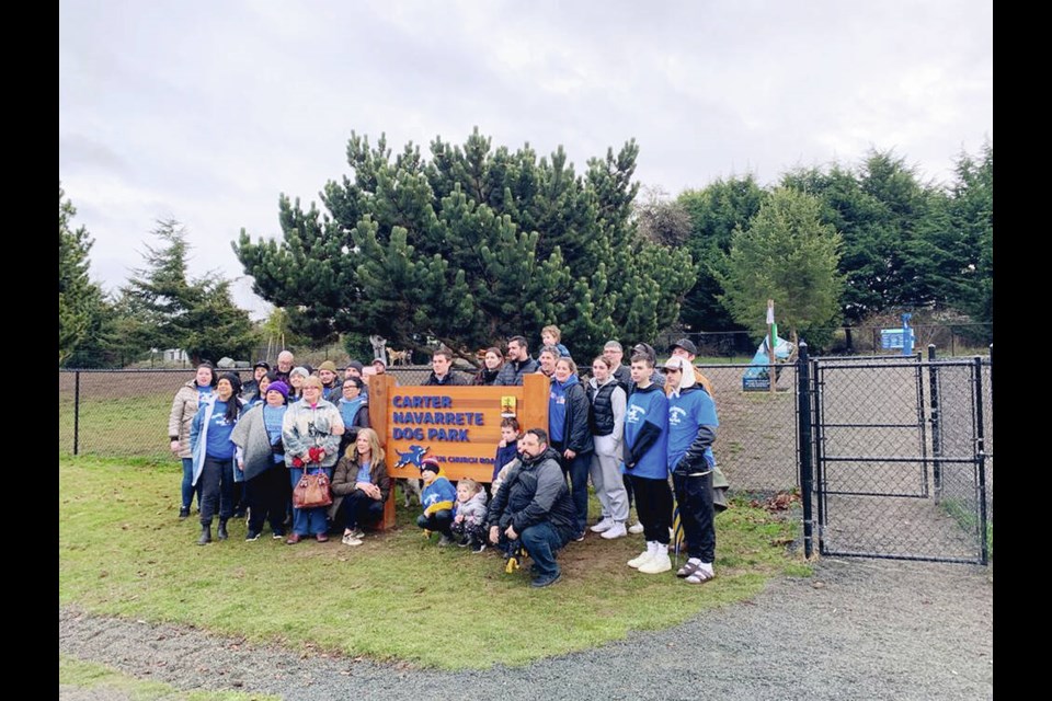 Family and friends of Carter Navarrete gather around the new sign for the renamed Carter Navarrete Dog Park in Sooke. Via District of Sooke 