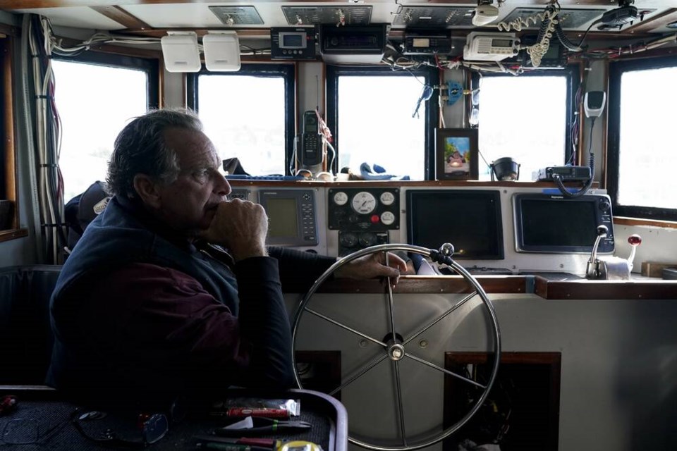 Bob Maharry sits inside his fishing boat docked at Pier 45 in San Francisco, Monday, March 20, 2023. This would usually be a busy time of year for Maharry and his crew as salmon fishing season approaches. On April 7, the Pacific Fishery Management Council, the regulatory group that advises federal officials, will take action on what to do about the 2023 season for both commercial and recreational salmon fishing. (AP Photo/Godofredo A. Vásquez)