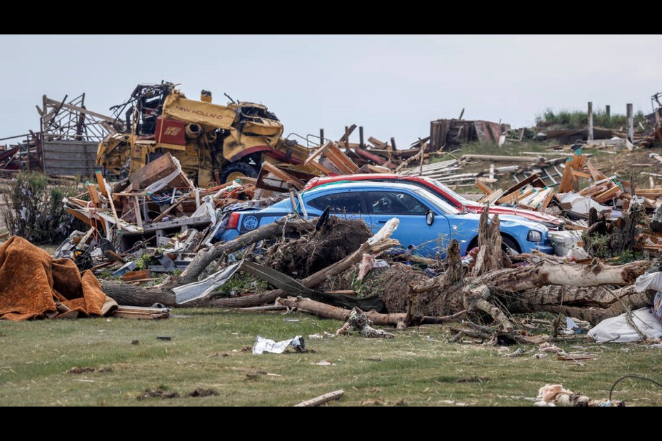 Vehicles sit amidst a tornado damaged home near Carstairs, Alta., Saturday, July 1, 2023. No injuries were reported. THE CANADIAN PRESS/Jeff McIntosh