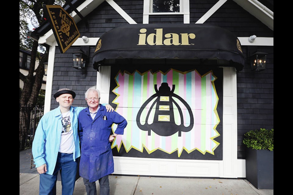 Jewelry designer Idar Bergseth, right, and artist Shawn Shepherd in front of a mural painted on plywood that’s temporarly covering a window opening. ADRIAN LAM, TIMES COLONIST 