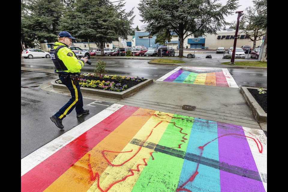 West Shore RCMP Const. Sean Van Londersele investigates vandalism at the Spencer Middle School Pride crosswalk on Goldstream Avenue. The new crosswalk was marred by tire marks and red paint shortly after it was completed by City of Langford workers. Story, A5 DARREN STONE, TIMES COLONIST 