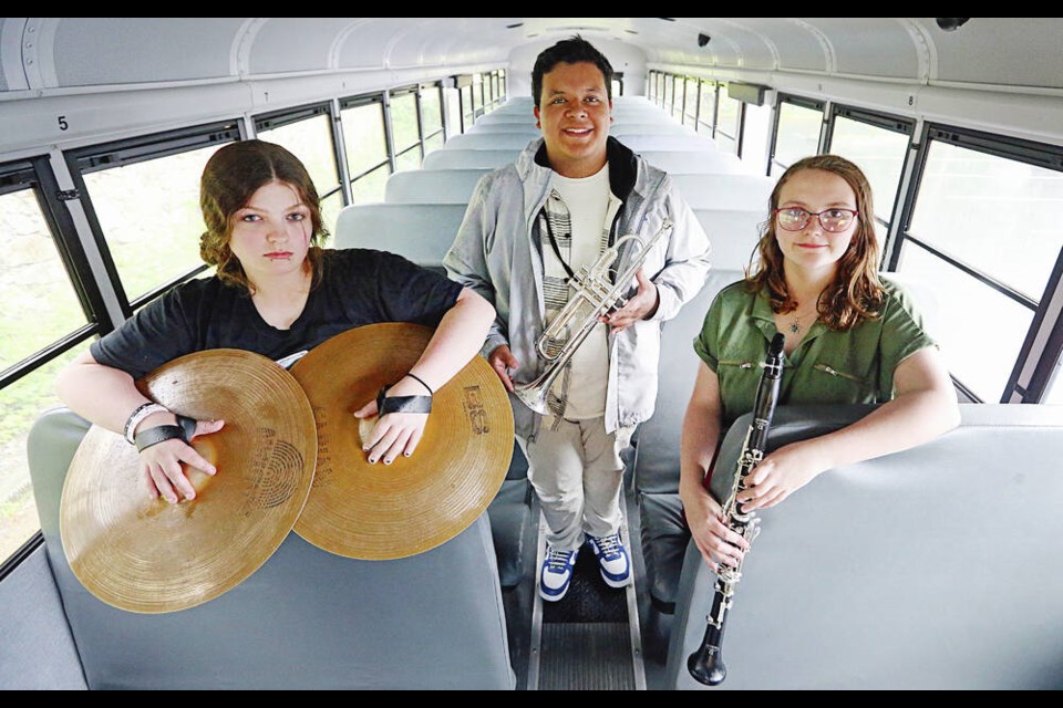Amani Scroggs, left, Angel Romero and Lily Shores on their bus with their musical instruments. The members of the Hoquiam High 
marching band from Hoquiam, Washington, will be performing in the Thrifty Foods Victoria Day Parade on Monday.  ADRIAN LAM, TIMES COLONIST 