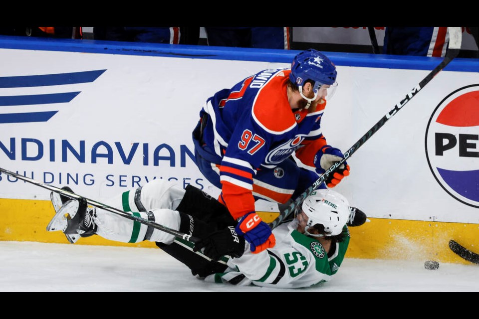 Dallas Stars forward Wyatt Johnston (53) is checked by Edmonton Oilers forward Connor McDavid (97) during third period of Game 6 of the Western Conference finals of the NHL hockey Stanley Cup playoffs in Edmonton, Sunday, June 2, 2024.THE CANADIAN PRESS/Jeff McIntosh